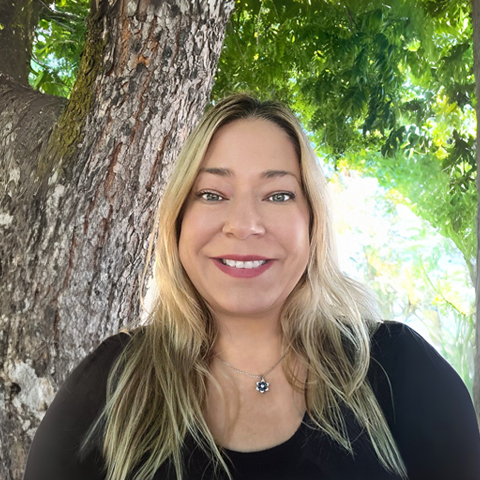 Carrie Hogue smiling in front of a tree